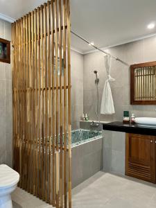 a bathroom with a shower and a toilet and a sink at Villa Puriartha Ubud - CHSE Certified in Ubud