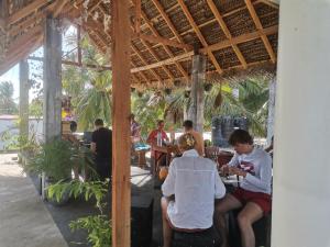 a group of people sitting at tables in a restaurant at Bashi eco beach cabana in Trincomalee