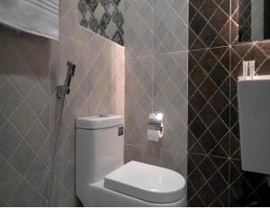 een badkamer met een toilet en een tegelwand bij Bed and Breakfast 430 in Islamabad