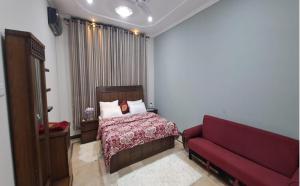 a bedroom with a bed and a red couch at Bed and Breakfast 430 in Islamabad
