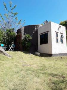 una pequeña casa en un patio con un campo de hierba en หมอกอิงธาร รีสอร์ท เขาค้อ, en Ban Khao Ya Nua