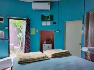 a blue room with a bed with two pillows on it at หมอกอิงธาร รีสอร์ท เขาค้อ in Ban Khao Ya Nua