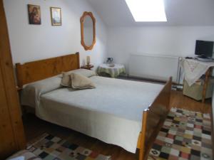 a bedroom with a bed and a mirror on the wall at Pensiunea Casa Filoxenia in Horezu