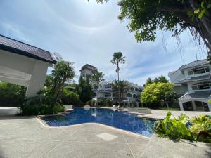 a swimming pool in front of some houses at Pooh Beach Resort & Spa in Jomtien Beach