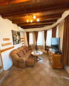 a living room with a couch and a flat screen tv at Complex Ristanite in Elena