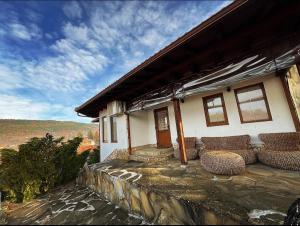 a house with chairs sitting on a stone wall at Complex Ristanite in Elena