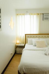 a bedroom with two beds and a window at Peaceful & quiet 1BR condo w/ pool access, TV&Wifi in Davao City