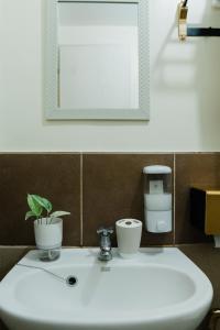 a bathroom sink with a potted plant and a mirror at Peaceful & quiet 1BR condo w/ pool access, TV&Wifi in Davao City