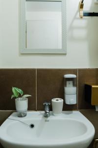 a bathroom sink with a potted plant and a mirror at AR01 Peaceful & quiet 1BR condo w pool access TV&Wifi in Davao City