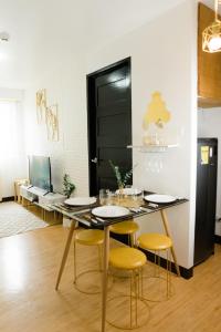 a dining room with a table and yellow chairs at Peaceful & quiet 1BR condo w/ pool access, TV&Wifi in Davao City