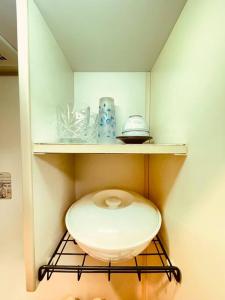 une étagère avec des toilettes dans une petite pièce dans l'établissement 駅から徒歩5分！便利リーズナブル, à Tokyo