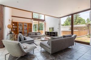 sala de estar con sofás, sillas y TV en MAISON GAÏA, en Hières-sur-Amby