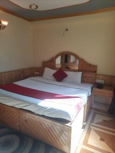 a bedroom with a wooden bed in a room at A Tree Homestay in stream in Manāli