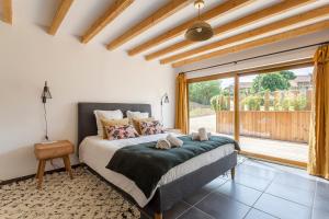 1 dormitorio con cama y ventana grande en MAISON GAÏA, en Hières-sur-Amby