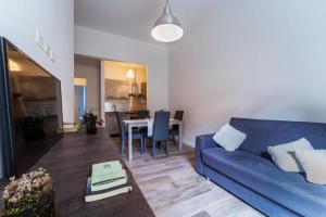 Una sala de estar con un sofá azul y una mesa. en Florence Gard, en Florencia