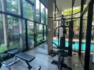 einen Fitnessraum mit einem Fitnessraum und einem Pool in der Unterkunft Palm Spring Fountain 1 BDR @Nimman #Pool #Gym #Workcation in Chiang Mai