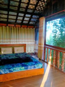 - une chambre avec un lit et une grande fenêtre dans l'établissement Homestay Làng Tôi - Pleiku - Gia Lai, à Plei Brêng