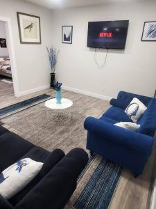 sala de estar con 2 sofás azules y TV en Family-Friendly, NETFLIX, Cozy Comfy 2 bed room basement suite,sleeps 5 en Edmonton