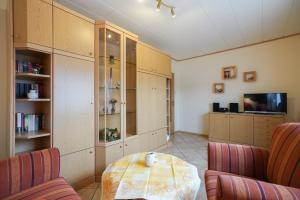 a living room with a table and a tv at J. Apfeld Ferienwohnungen in Borkum