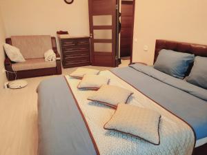 a bedroom with two beds with pillows and a chair at Отдельная Квартира со всеми удобствами in Chişinău