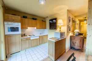 une grande cuisine avec des placards en bois et un four micro-ondes dans l'établissement Ancolie 1er, à Val dʼIsère 4 autres photos