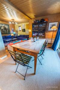 - une grande table en bois avec des chaises dans l'établissement Ancolie 1er, à Val dʼIsère