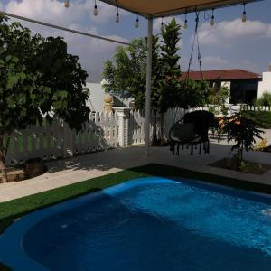 a swimming pool in a yard with a fence and a cow at استراحة الدرر خاصه لنساء ولازواج 