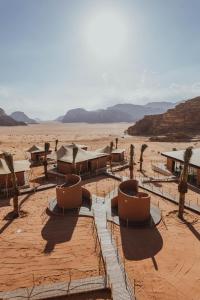 una zona desértica con mesas y sillas en el desierto en Valley Resort en Wadi Rum