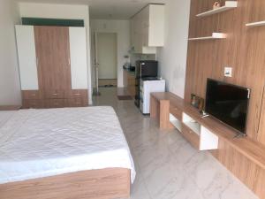 a bedroom with a bed and a flat screen tv at Căn hộ 1br Ocean Vista - SeaHome in Phan Thiet