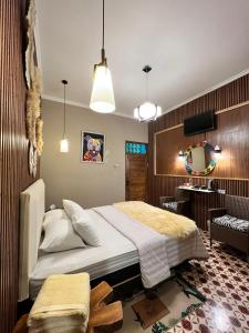 a bedroom with a bed and a desk in it at Bhumi Sammy by Sammy Home Yogyakarta in Timuran