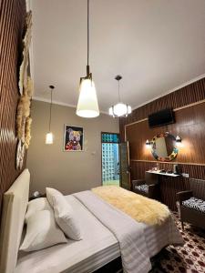 a bedroom with a bed and a mirror and lights at Bhumi Sammy by Sammy Home Yogyakarta in Timuran