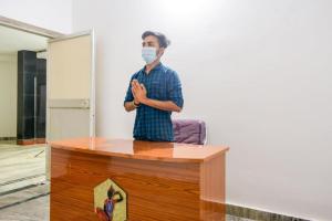 a man standing behind a desk with a mask on at Goroomgo Elite Stay Bhubaneswar in Bhubaneshwar