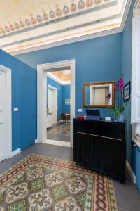 a blue room with a mirror on the wall at casa mo room and suite in Palermo