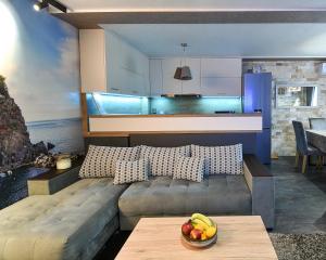 ein Wohnzimmer mit einer Couch und einer Obstschale auf einem Tisch in der Unterkunft Апартамент Девио in Ruse