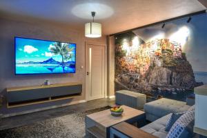 ein Wohnzimmer mit einem großen TV an der Wand in der Unterkunft Апартамент Девио in Ruse