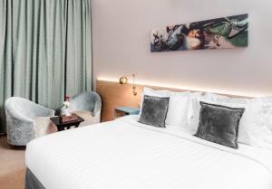 麥加的住宿－M Hotel Al Dana Makkah by Millennium，酒店客房带一张大床和两张椅子