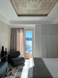 una camera con un letto e una grande finestra di Kratísti a Ermoupoli