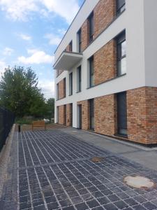 a brick building with a bench in front of it at Apartamenty Jaskółcza in Bydgoszcz