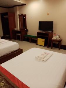 Postel nebo postele na pokoji v ubytování Soubundith Hotel