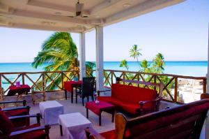 a balcony with chairs and tables and the ocean at Room in BB - Room Viv glaund flow with 2 guests in Nungwi