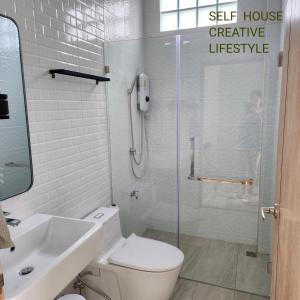 y baño con aseo, ducha y lavamanos. en Self house (Cozy private house) en Hat Yai