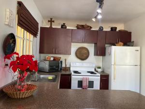 a kitchen with a white stove and a white refrigerator at Hotel y villas palma Real . in La Ceiba