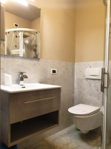 y baño con lavabo, aseo y espejo. en Piccolo Hotel Olina, en Orta San Giulio
