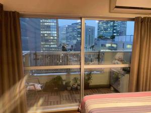 a bedroom with a balcony with a view of a city at 駅徒歩5分！快適で贅沢、理想的なゲストルーム in Tokyo