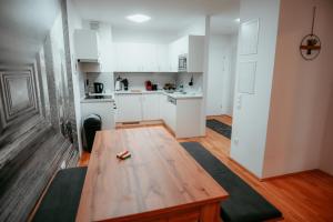 a living room with a wooden table and a kitchen at Vienna Cozy Apartment 105 in Vienna