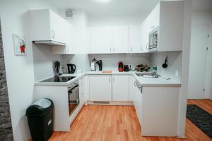 a white kitchen with white cabinets and a wooden floor at Vienna Cozy Apartment 105 in Vienna +19 photos