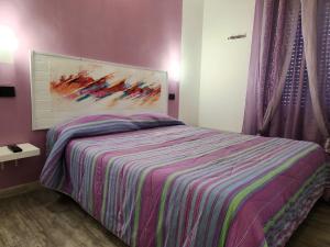 een slaapkamer met een bed met een schilderij aan de muur bij IDEA in Alghero