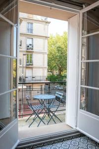 an open door to a balcony with a table and chairs at Happy Trip - Hypercentre in Le Havre