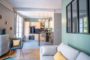 a living room with a couch and a kitchen at Happy Trip - Hypercentre in Le Havre