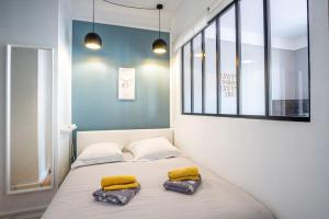 a bedroom with a bed with two yellow pillows on it at Happy Trip - Hypercentre in Le Havre